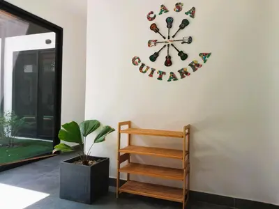 a clock on a wall next to a plant at Playa Potrero - NEW modern house, pool in guitar shape - Casa Guitarra in Potrero