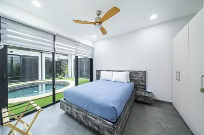 a bedroom with a bed and a swimming pool at Playa Potrero - NEW modern house, pool in guitar shape - Casa Guitarra in Potrero