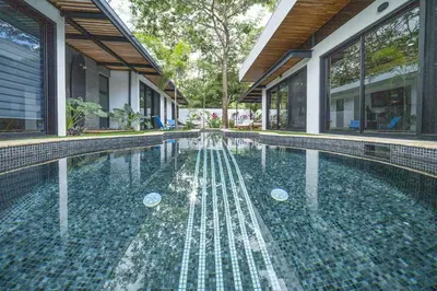 a swimming pool in front of a house at Playa Potrero - NEW modern house, pool in guitar shape - Casa Guitarra in Potrero