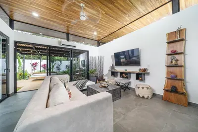 a living room with a couch and a tv at Playa Potrero - NEW modern house, pool in guitar shape - Casa Guitarra in Potrero
