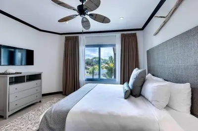 a bedroom with a bed with a ceiling fan and a window at Diamante del Sol 202N - 2nd Floor Ocean View in Jacó