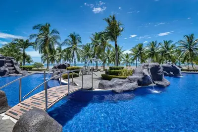 a pool at the resort with palm trees at Diamante del Sol 202N - 2nd Floor Ocean View in Jacó