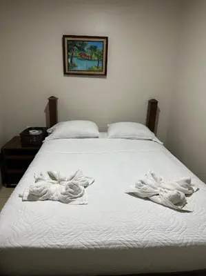 a white bed with towels on top of it at Rivera Family Airport Apartments in Santiago Este