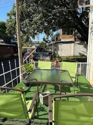 a green table and chairs sitting on a patio at Rivera Family Airport Apartments in Santiago Este