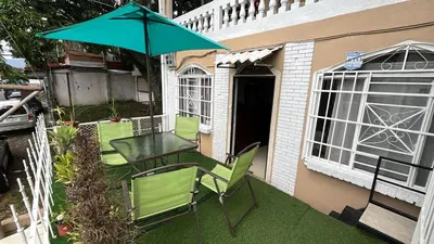a patio with a table and chairs and an umbrella at Rivera Family Airport Apartments in Santiago Este