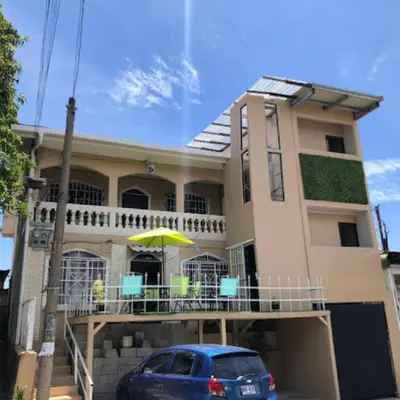 a house with a car parked in front of it at Rivera Family Airport Apartments in Santiago Este