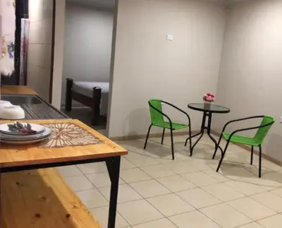 a dining room with green chairs and a table at Rivera Family Airport Apartments in Santiago Este