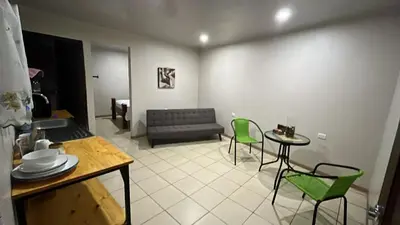 a living room with a couch and a table and chairs at Rivera Family Airport Apartments in Santiago Este