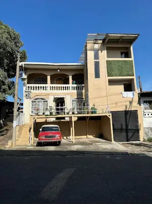 a red car parked in front of a building at Rivera Family Airport Apartments in Santiago Este