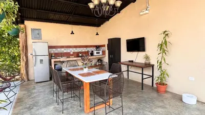 a patio with a table and chairs and a refrigerator at Apartamento el Guanacaste, cerca Tamarindo con Piscina in Santa Cruz