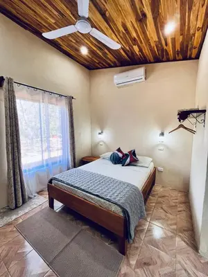 a bedroom with a bed with a wooden ceiling at Apartamento el Guanacaste, cerca Tamarindo con Piscina in Santa Cruz