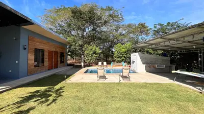 a backyard with two chairs and a pool at Apartamento el Guanacaste, cerca Tamarindo con Piscina in Santa Cruz