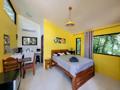 a bedroom with a bed and a kitchen with a sink at Villa Martina Palmgarden in Sámara