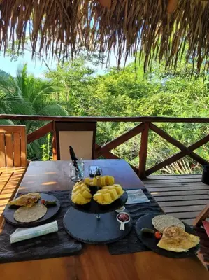 a table with plates of food on top of a deck at Villa Martina Palmgarden in Sámara