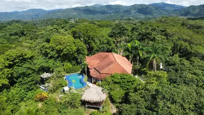 an aerial view of a house in the forest at Villa Martina Palmgarden in Sámara
