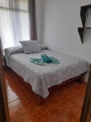 a bed with a blue robe on top of it at Twin Palms house in Monteverde Costa Rica