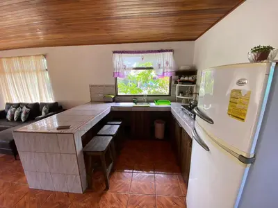 a kitchen with a refrigerator and a table in it at Twin Palms house in Monteverde Costa Rica
