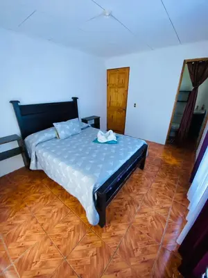 a bedroom with a bed and a wooden floor at Twin Palms house in Monteverde Costa Rica