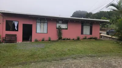 a red house with a yard in front of it at Twin Palms house in Monteverde Costa Rica