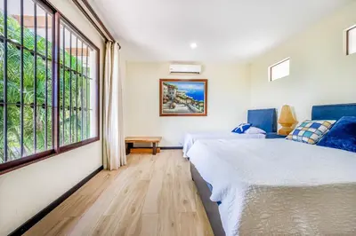 a bedroom with two beds and a large window at Villa Casiopea in Carpintero