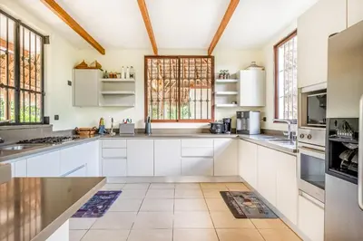 a kitchen with white cabinets and windows at Villa Casiopea in Carpintero
