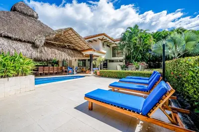 a group of blue lounge chairs next to a swimming pool at Villa Casiopea in Carpintero