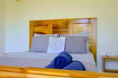 a bedroom with a bed with blue and white pillows at Canavida Villas & Resort in Uvita