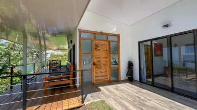 a balcony with a wooden door on a house at Canavida Villas & Resort in Uvita