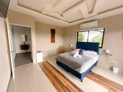 a bedroom with a blue bed and a window at Casa Garitas GuestHouse & Car Rental - Free SJO Airport Shuttle - Nationwide Private Shuttle Services - casagaritas com in Santiago Este