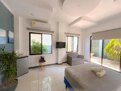 a bedroom with a bed and a tv and some windows at Casa Garitas GuestHouse & Car Rental - Free SJO Airport Shuttle - Nationwide Private Shuttle Services - casagaritas com in Santiago Este