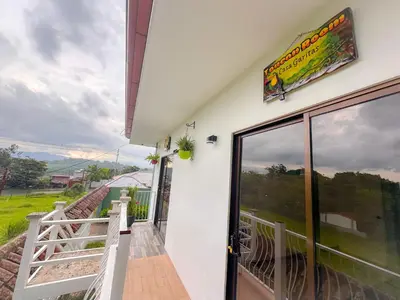 a balcony of a house with a view of a field at Casa Garitas GuestHouse & Car Rental - Free SJO Airport Shuttle - Nationwide Private Shuttle Services - casagaritas com in Santiago Este