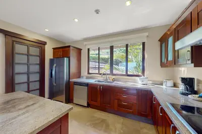 a kitchen with wooden cabinets and a stainless steel refrigerator at Azul Paraíso 2B in Ocotal