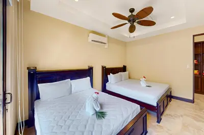 a bedroom with two beds and a ceiling fan at Azul Paraíso 2B in Ocotal