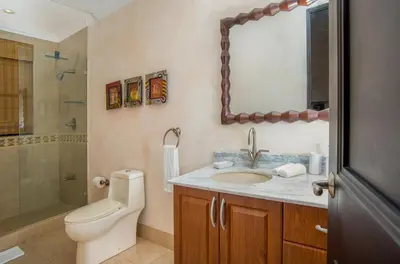 a bathroom with a sink and a toilet and a mirror at Luxurious 3BR Ocean-View Condo - Malinche - Reserva Conchal in Playa Conchal