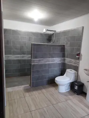 a bathroom with a toilet and a shower at Anchia - Hostel in Alajuela City