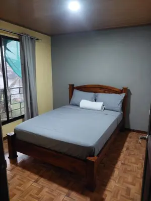 a bedroom with a bed in a room with a window at Anchia - Hostel in Alajuela City