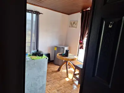 a small room with a table and a kitchen at Anchia - Hostel in Alajuela City