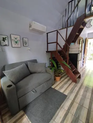 a living room with a couch and a staircase at Chalet La Fortuna YeyYe in Fortuna