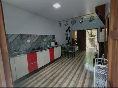 a kitchen with red and white cabinets and a table at Chalet La Fortuna YeyYe in Fortuna