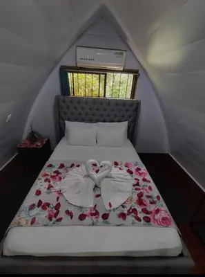 a bed with two white roses on top of it at Chalet La Fortuna YeyYe in Fortuna