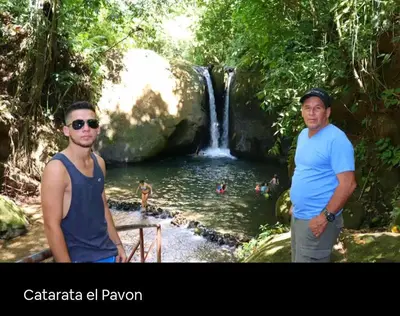 two men standing in front of a waterfall at Cabaña Eco-Arte in Tortugal