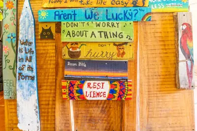 a bulletin board with signs on a wall at Casa Terra Hostel in Sámara