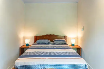 a bedroom with a bed with two lamps on tables at Casa Terra Hostel in Sámara