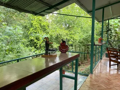 a screened in porch with a table and chairs at Campo Verde House, La Fortuna de San Carlos in Fortuna