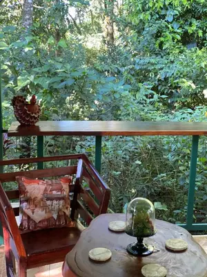 a table and chairs on a porch with a view of a forest at Campo Verde House, La Fortuna de San Carlos in Fortuna