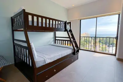 a bedroom with two bunk beds and a large window at Elegant Oceanview Penthouse - Steps from Jaco Beach & Nightlife in Jacó