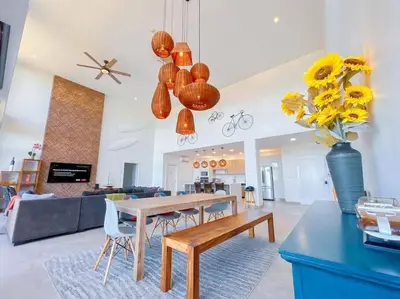a living room with a table and a vase of flowers at Elegant Oceanview Penthouse - Steps from Jaco Beach & Nightlife in Jacó