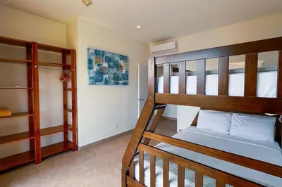a room with two bunk beds and a staircase at Elegant Oceanview Penthouse - Steps from Jaco Beach & Nightlife in Jacó