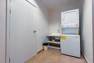 a kitchen with a refrigerator and a tv on top at Elegant Oceanview Penthouse - Steps from Jaco Beach & Nightlife in Jacó