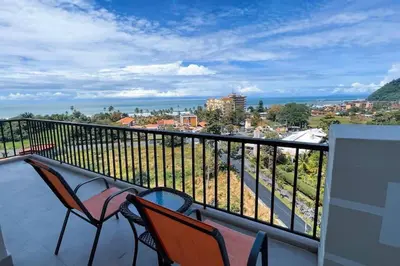 two chairs on a balcony with a view of the ocean at Elegant Oceanview Penthouse - Steps from Jaco Beach & Nightlife in Jacó